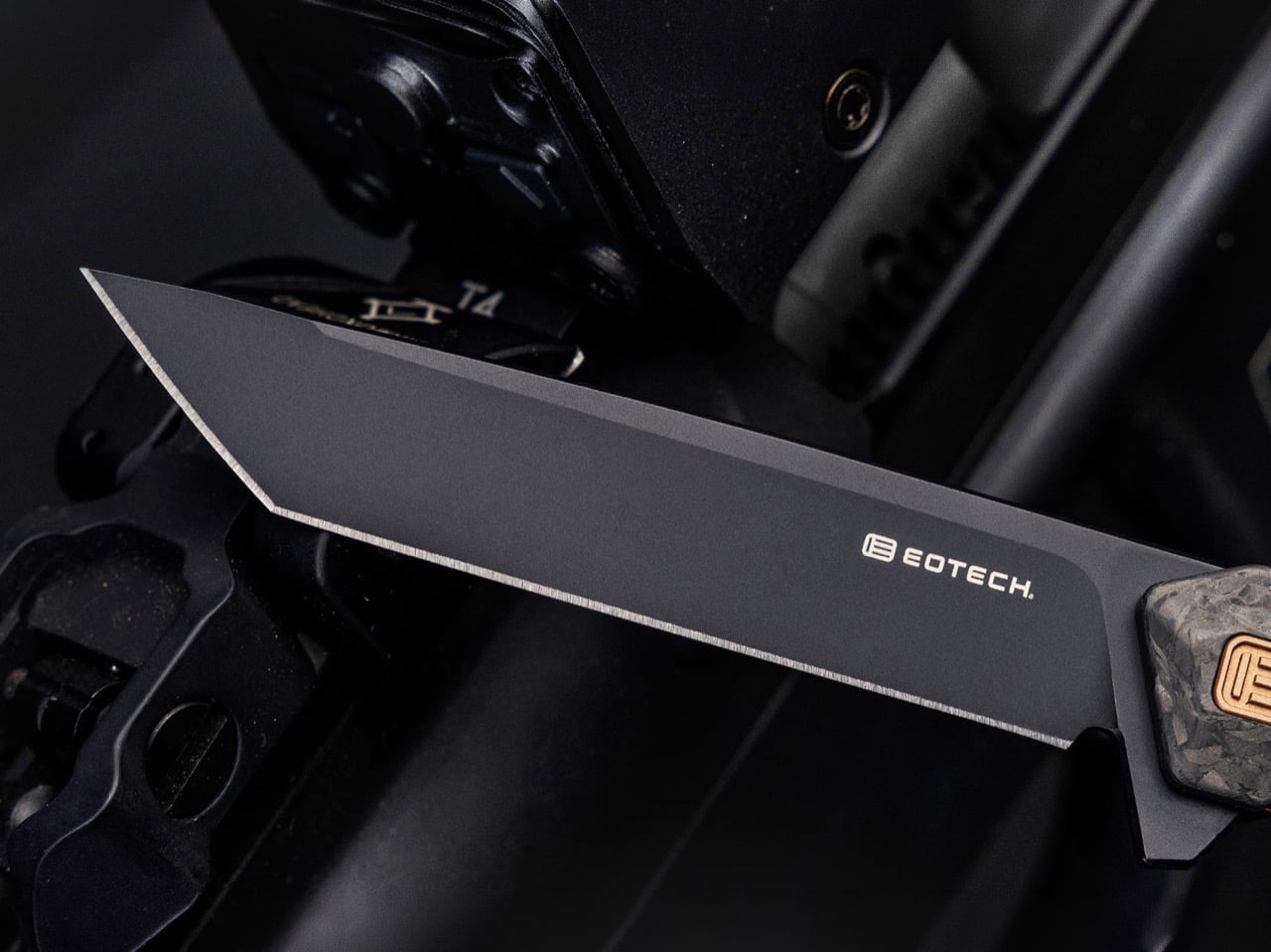 Close-up of a matte gray EOTech knife blade mounted on a rail system, edge facing left.
