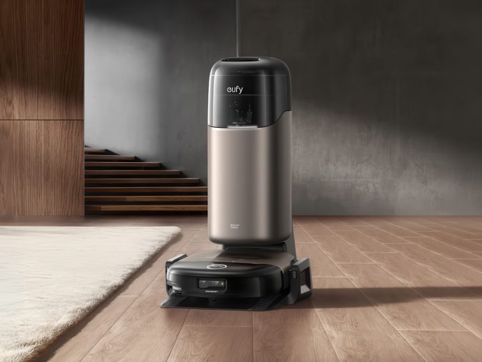 Eufy robot vacuum on its charging dock in a modern living room with wooden floor and neutral walls