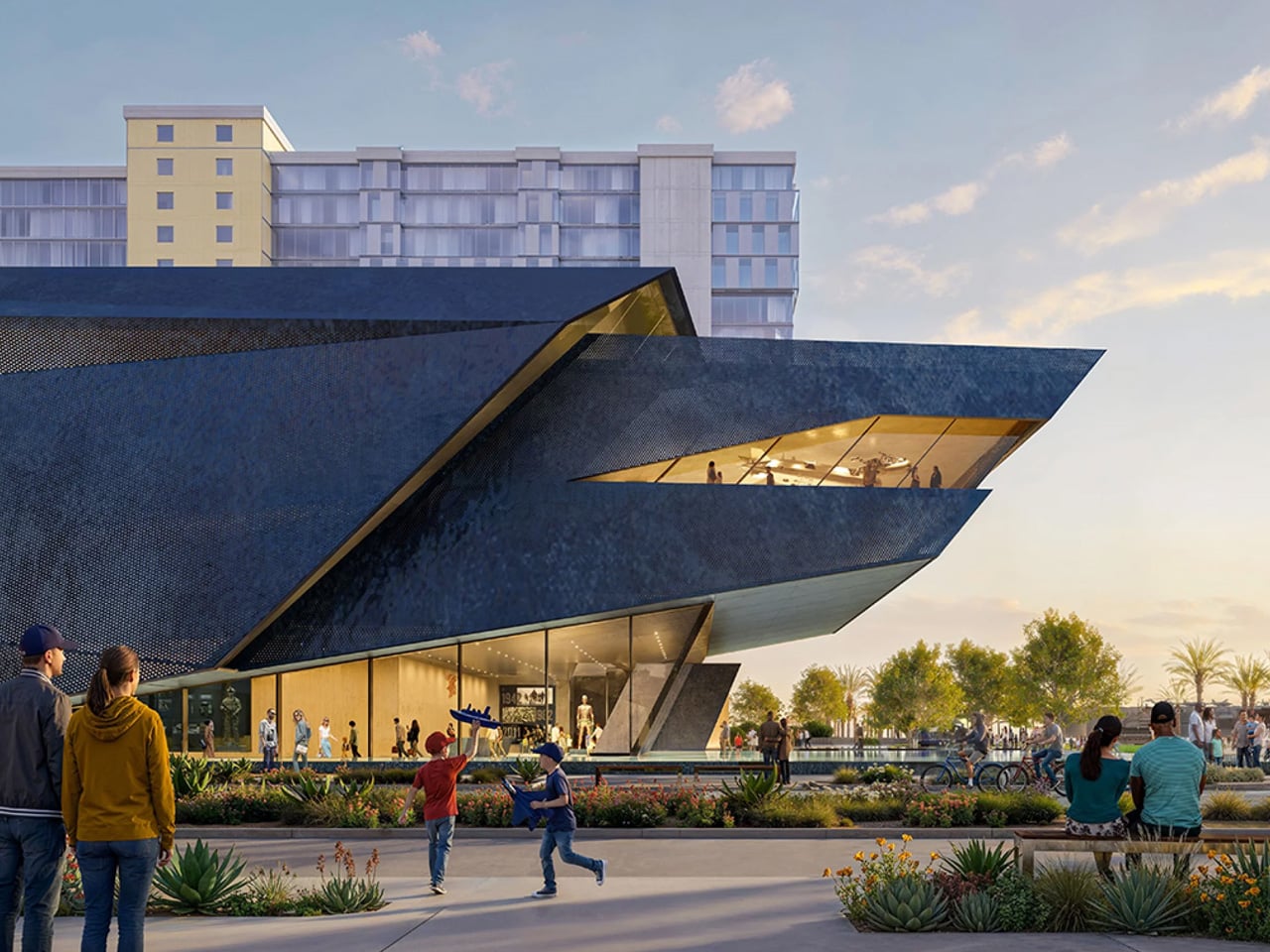 Contemporary angular building with a glass façade, as people walk and gather in a sunny plaza in front of it.