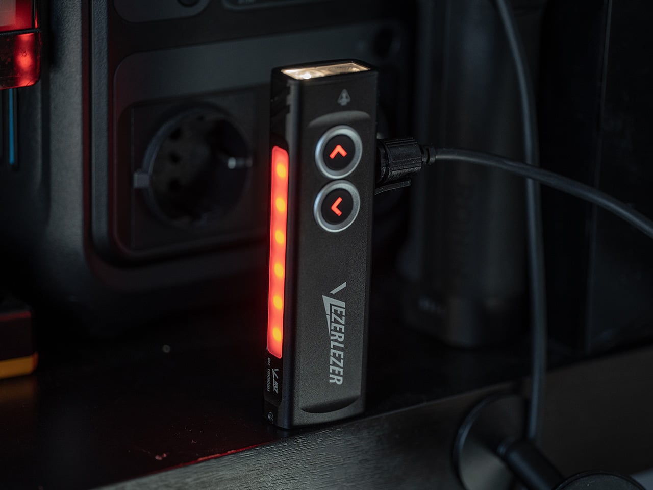 Black PC LED/fan controller with two arrow buttons and a vertical red LED bar inside a computer case.