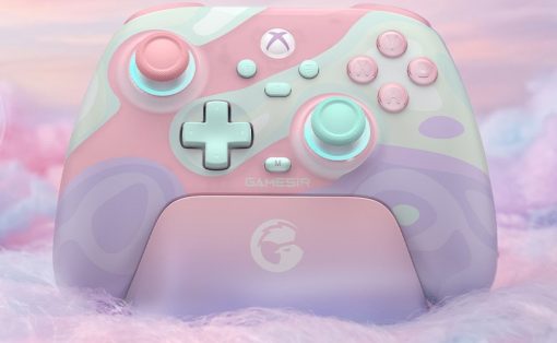 Pastel pink and mint Xbox wireless controller on a matching charging dock with a fluffy pastel backdrop.
