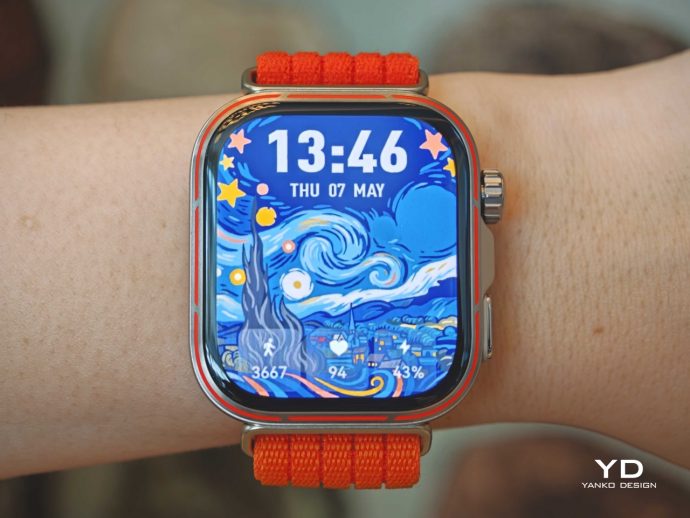 Smartwatch with orange band on the wrist, showing a Starry Night–inspired face and the time 13:46.