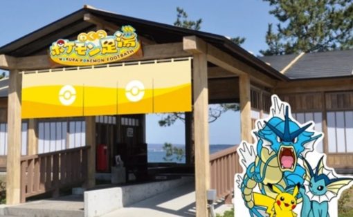 Wooden pavilion with a yellow Pokemon banner over the entrance and large Pokemon cutouts (Pikachu and blue dragon-type figures) beside it by the sea view entrance.