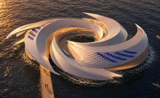 Aerial view of a futuristic white spiral pavilion on the sea, connected by a wooden pier at sunset.