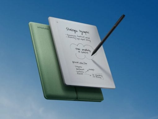 Green reMarkable notebook with open white page and a black stylus, floating against a blue sky.