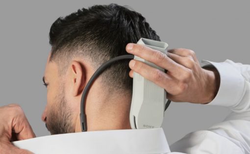Man getting a neck trim with a cordless hair trimmer held behind his ear in a barber’s chair.