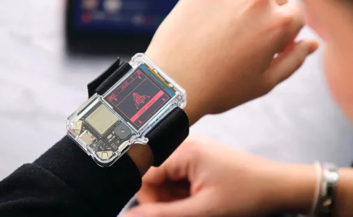 Transparent smartwatch on the wrist showcasing exposed internal circuitry during a demonstration.