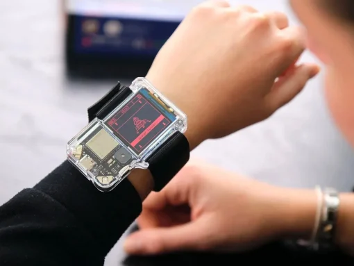 Transparent smartwatch on the wrist showcasing exposed internal circuitry during a demonstration.
