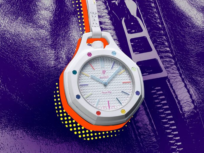 White two-tone wristwatch with colorful hour markers and a textured dial, set against a purple leather background.