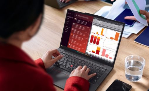 Person typing on a laptop displaying Slack-style chat on the left and colorful charts on the right during a meeting scene.