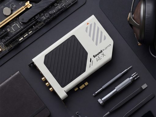 Sound Blaster AE-X external sound card on a dark desk with precision tools and headphones nearby.