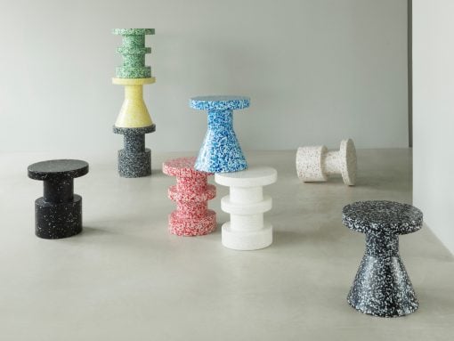 Colorful speckled terrazzo stools arranged in a gallery, stacked and standing, in black, white, red, blue, yellow, green tones