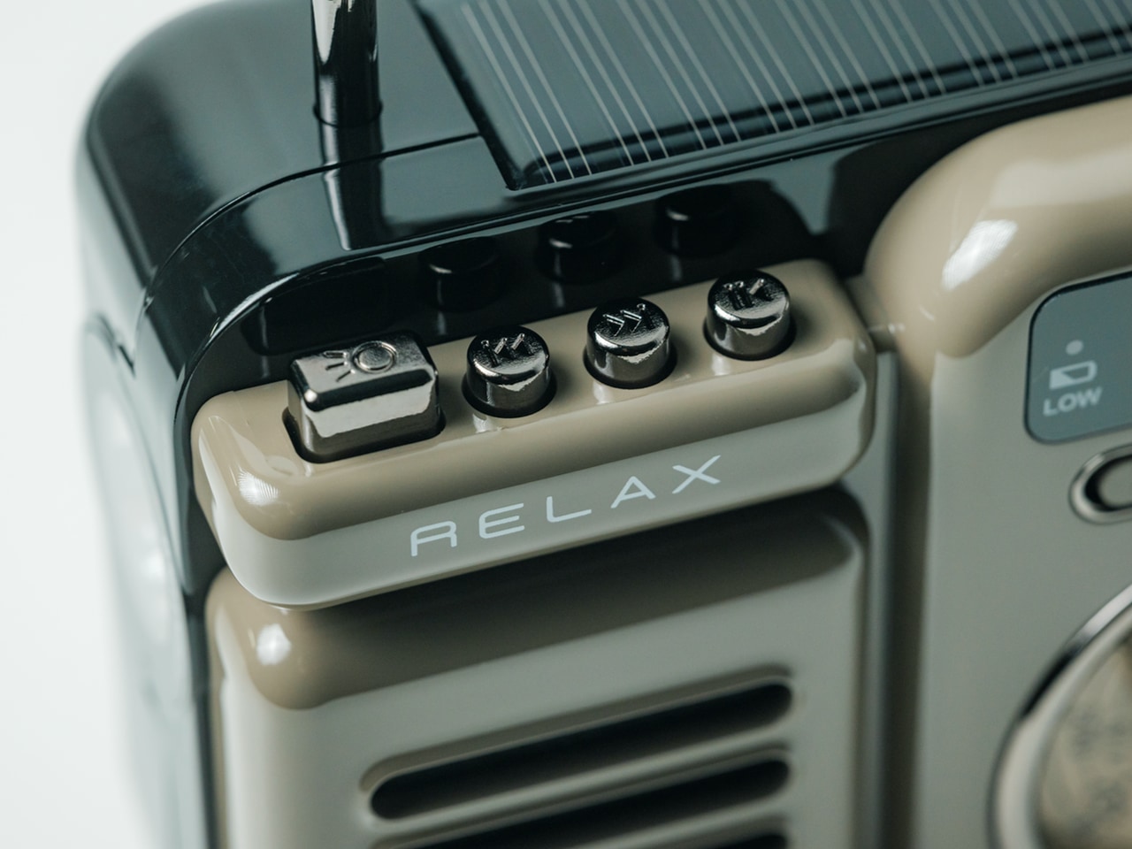 Close-up of a vintage beige control panel with four small knobs and a 'RELAX' label on a glossy black device.