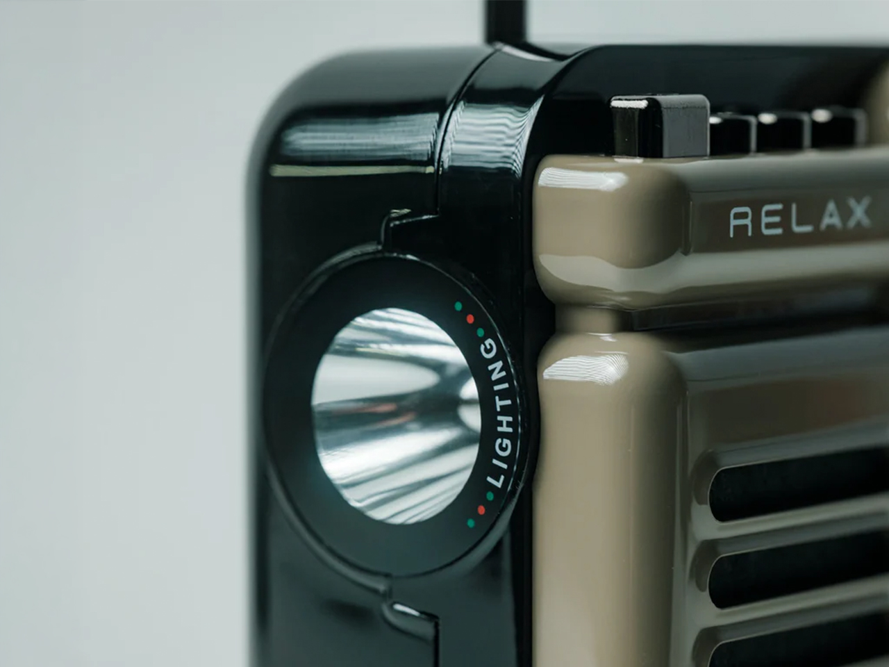 Close-up of a black device with a circular dial labeled 'LIGHTING' and small red/green indicators, beside a beige panel that says 'RELAX'.