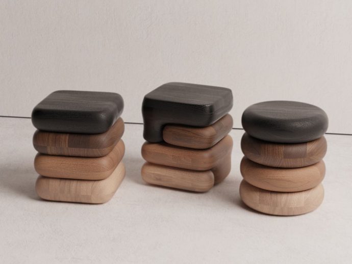 Three stacks of smooth, rounded wooden blocks in dark, mid, and light browns on a pale surface.