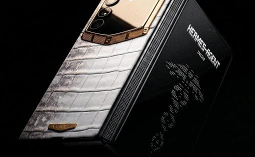 Luxurious Vertu smartphone with white crocodile leather back and gold camera module, Hermes edition, against a dark backgroundie.