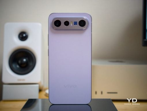 Purple Vivo smartphone standing upright on a desk, showing a triple camera module labeled Zeiss on the top edge.