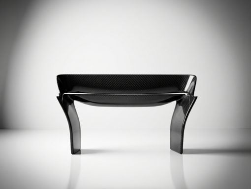 Carbon fiber bench with sculpted curved legs in a bright studio setting