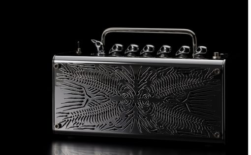 Shiny black metal case with a chrome handle and embossed abstract pattern, resting on a reflective surface against a black background.