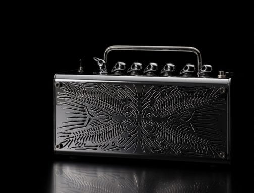 Shiny black metal case with a chrome handle and embossed abstract pattern, resting on a reflective surface against a black background.