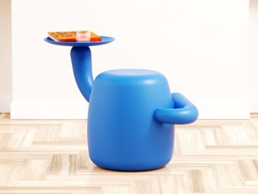 Blue rounded stool with a curved arm holding a small tray on top, which supports a book and a glass.