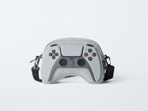 Grey PlayStation controller-shaped bag with buttons, hand straps, and adjustable crossbody strap.