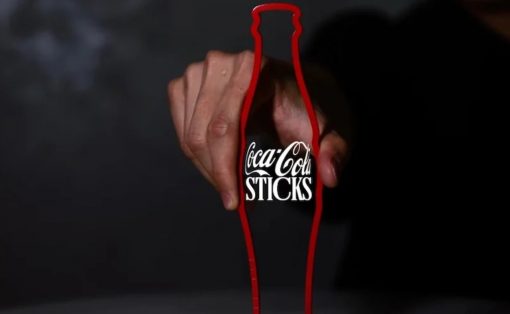 Hand gripping a Coca-Cola bottle outline drawn in red, with the text 'Coca-Cola STICKS' visible on the bottle