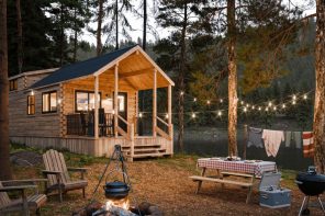 This 400-Square-Foot Log Cabin Has a Loft, a Covered Porch, and Cathedral Ceilings — and It Arrives on a Flatbed