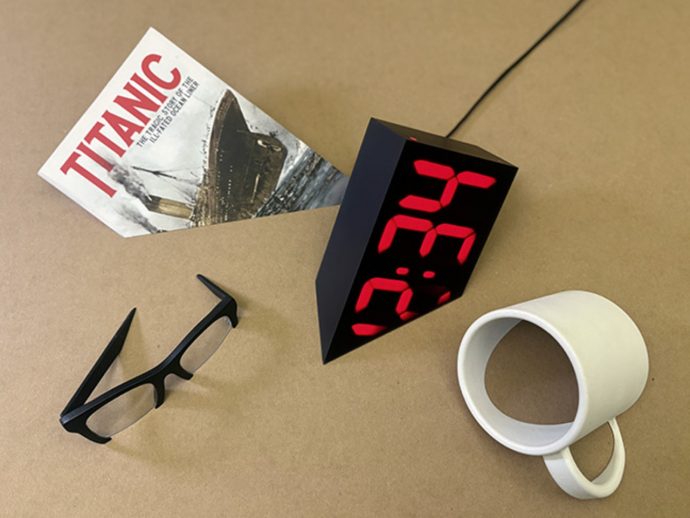 This Clock Looks Like It’s Sinking Into a Desk and It’s Not a Trick