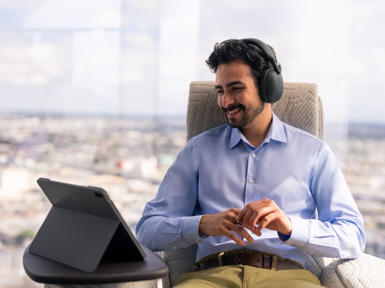 Man wearing graphite Logitech Zone Vibe Pro headphones during a video call on a tablet